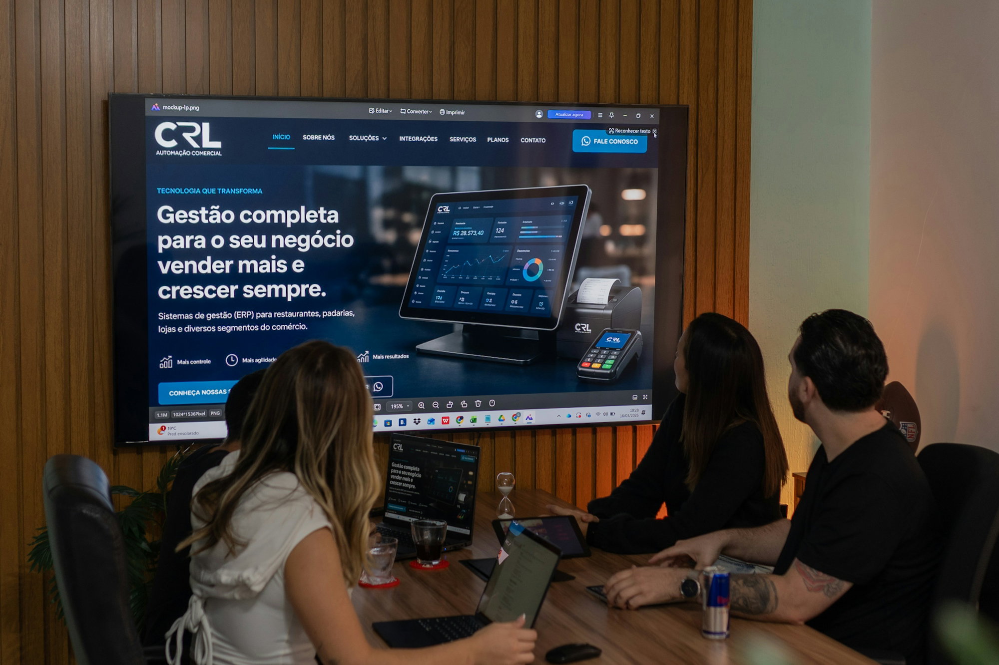 Three colleagues viewing a business presentation on a large screen.